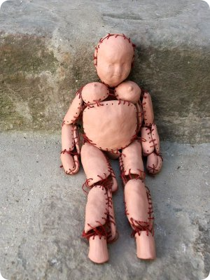 Petite poupée, céramique, fils rouge